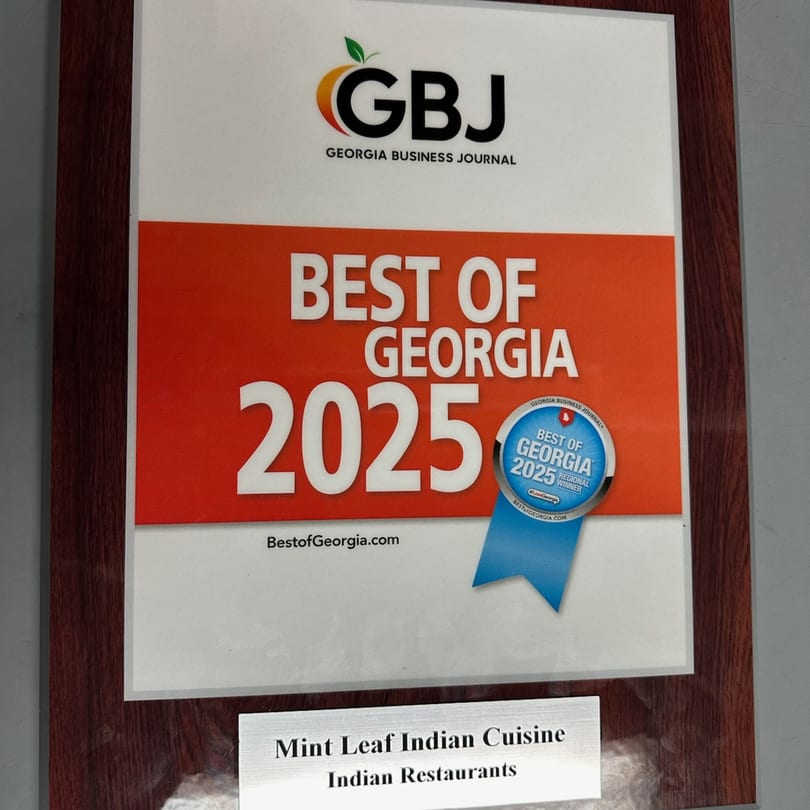 A framed "Best of Georgia 2025" award from the Georgia Business Journal for Mint Leaf Indian Cuisine.