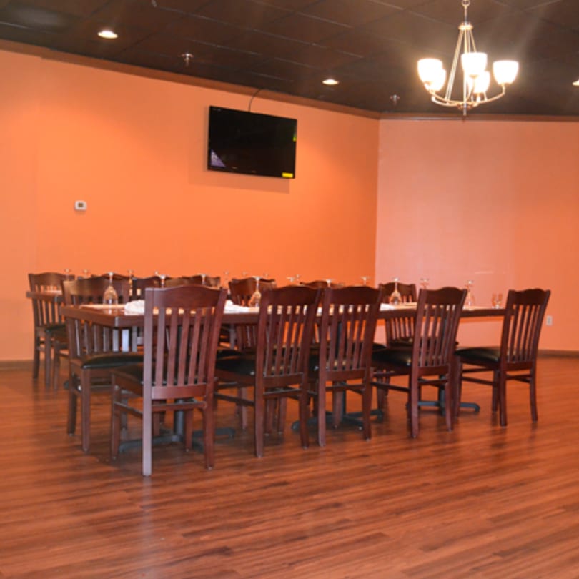 A private dining room at Mint Leaf Indian Cuisine with a long table set for many guests.