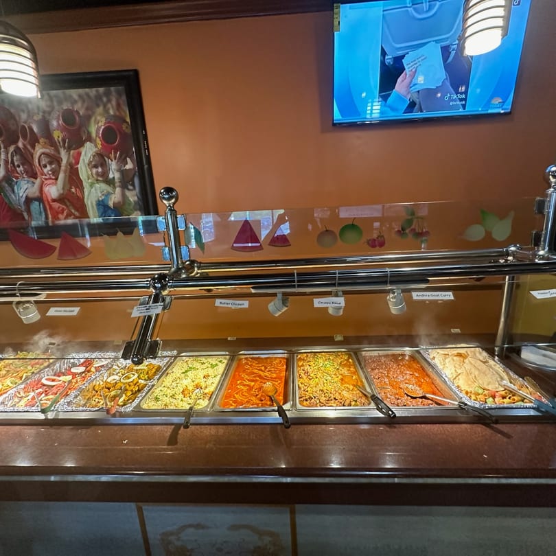 A buffet line at Mint Leaf Indian Cuisine with various Indian dishes in steam tables.